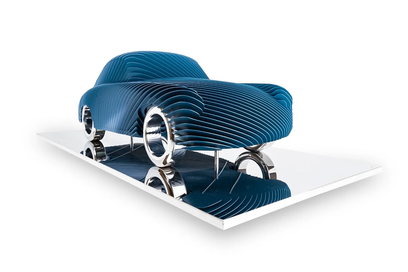 Antoine Dufilho – Porsche 356 Blue Het kunstwerk Porsche 356 Blue van Antoine Dufilho ademt beweging en elegantie. De sculptuur vangt de iconische vormen van de klassieke Porsche 356. Laag na laag opgebouwd, ontstaat een dynamisch spel van lijnen en open ruimtes. Hierdoor lijkt de auto voortdurend in beweging, ook wanneer hij stil staat. De blauwe kleur versterkt het gevoel van snelheid en moderniteit. De glanzende metalen basis reflecteert de sculptuur, waardoor er een extra dimensie aan diepte ontstaat. Dufilho weet erfgoed en innovatie te combineren. De Porsche 356 was een pionier in sportwagens, en dit werk vertaalt die erfenis naar een kunstobject. Door gebruik te maken van ritmische lagen ontstaat er een architecturale harmonie. Elke hoek toont een nieuw perspectief, waardoor de kijker steeds verrast wordt. Dit maakt het beeld niet alleen een ode aan autogeschiedenis, maar ook een sculptuur die voortdurend uitnodigt tot ontdekken. De kunst van Antoine Dufilho speelt met balans. Enerzijds straalt de Porsche 356 Blue kracht en robuustheid uit. Anderzijds heeft het werk een lichte, bijna zwevende uitstraling. Dit contrast maakt het kunstwerk uniek. Bovendien benadrukt de keuze voor blauw vertrouwen, snelheid en creativiteit. Het geheel is een moderne interpretatie van een legende die zijn stempel op de autowereld drukte.