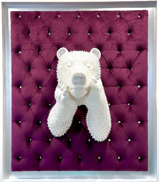 Tableau ZEN Purple – Eddy Maniez Een samensmelting van rust en luxe. Tableau ZEN Purple van Eddy Maniez trekt direct de aandacht door zijn diepe, koninklijke paarse achtergrond en de serene ijsbeer die zich door het zachte, gecapitonneerde oppervlak naar buiten laat zien. De glanzende afwerking, verrijkt met duizenden zorgvuldig aangebrachte silicone dots en Swarovski kristallen, creëert een hypnotiserend spel van licht en textuur. Dit werk ademt rust, maar straalt tegelijk onmiskenbare kracht uit. Het contrast tussen de zachtheid van het fluweel en de glinsterende details van de beer maakt dit kunstwerk uitzonderlijk intrigerend. Het tableau roept emoties op die balanceren tussen ontspanning en bewondering. Het geeft een gevoel van kalmte, terwijl de glanzende patronen voortdurend de aandacht blijven trekken. Daarom is dit kunstwerk niet alleen een lust voor het oog, maar ook een symbool van innerlijke balans en visuele harmonie. Wie dit werk in zijn ruimte plaatst, voegt onmiddellijk een iconische eyecatcher toe die gesprekken opent en tegelijkertijd een sfeer van rust bewaart.