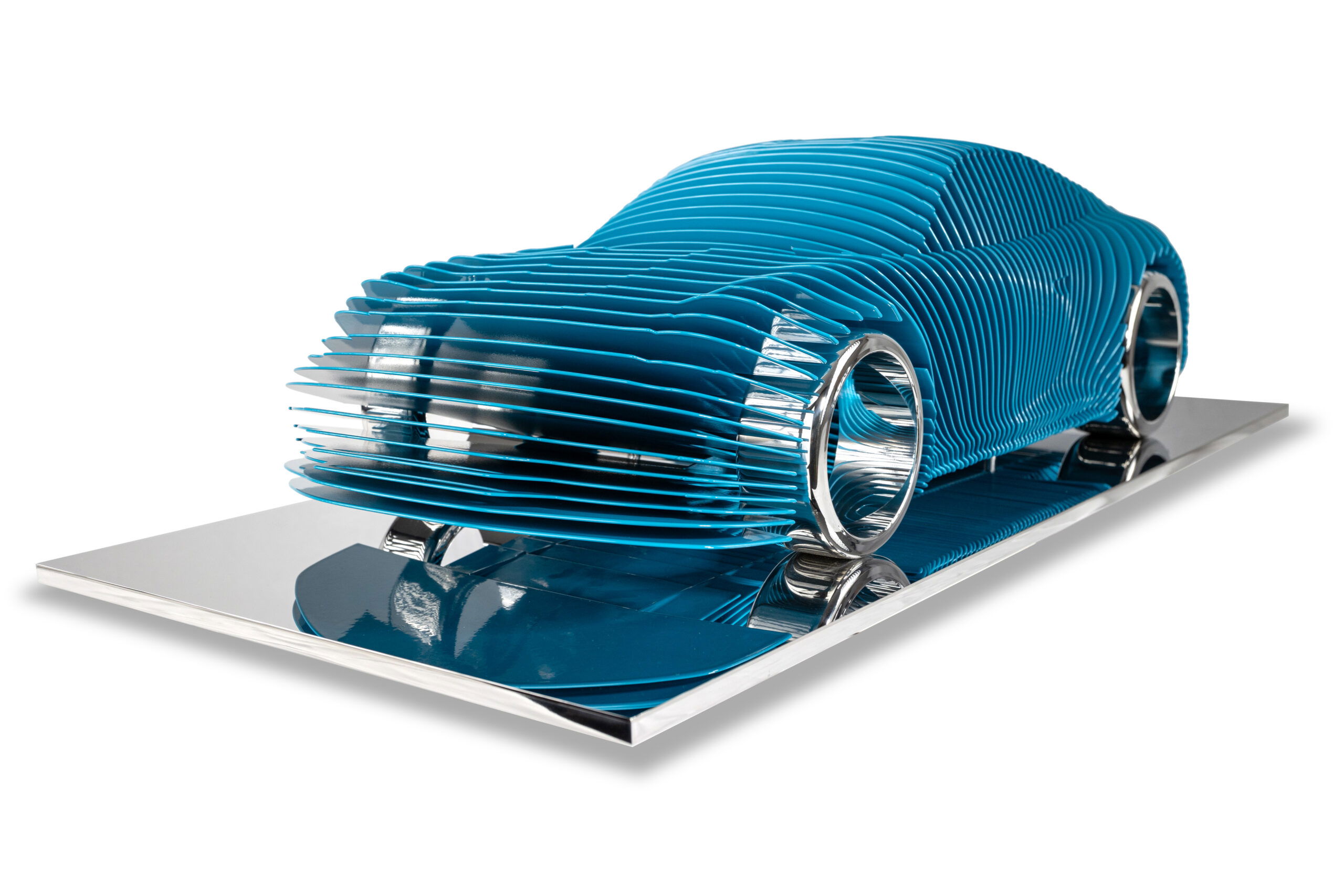 Antoine Dufilho – Porsche 991 GTS Blue De Porsche 991 GTS Blue van Antoine Dufilho is een sculptuur waarin techniek en kunst samenkomen. Het werk toont de iconische Porsche 991 GTS, maar in een volledig nieuwe vorm. De carrosserie is opgebouwd uit opeenvolgende lagen, strak en harmonieus geplaatst, waardoor het gevoel van snelheid en precisie direct zichtbaar wordt. Het diepe blauw geeft het werk een frisse en moderne uitstraling. De lijnen vloeien als golven over elkaar heen en creëren een ritme dat beweging en elegantie uitstraalt. Doordat de auto op een spiegelende basis staat, worden contouren en details nog intenser. Hierdoor ontstaat een dynamisch spel van licht en schaduw. Dufilho vertaalt de essentie van design en snelheid in een sculptuur die meer is dan een representatie. Het is een artistieke heruitvinding van de Porsche, waarbij innovatie en schoonheid hand in hand gaan. Vanuit elke hoek ontdekt de toeschouwer nieuwe perspectieven. Dit maakt het kunstwerk levendig, speels en tegelijkertijd tijdloos. De Porsche 991 GTS Blue is niet alleen een ode aan autodesign, maar ook een bewijs dat techniek kan transformeren in pure kunst. Het combineert perfectie met emotie en weet telkens weer te verrassen.