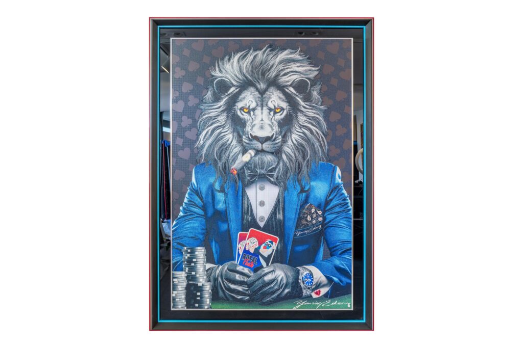 Yaniv Edery - Lion Poker Blue This impressive artwork by Yaniv Edery depicts a powerful lion dressed in a stylish blue suit. With a cigar in his mouth and cards firmly in his hand, he exudes confidence, power and strategy. The background full of subtle patterns emphasizes the luxurious atmosphere, while the lion's intense gaze grabs immediate attention. Every detail, from the sparkling watch to the sheen of the suit, contributes to a masterful balance between realism and fantasy. This work symbolizes more than just a game. It is about taking risks, winning and showing guts. The combination of animal strength and human elegance makes this work unique. It is not only a decorative artwork, but also a powerful statement piece that provokes conversation. Ideal for lovers of modern art, poker or those who like to add a touch of luxury to their interiors. The use of vibrant colors and sharp contrasts makes this piece of art continue to fascinate. The blue hues add tranquility and depth, while the red of the cards adds excitement. The bold style and strong composition give any room an exclusive look. A perfect choice for living rooms, offices or luxury collections.
