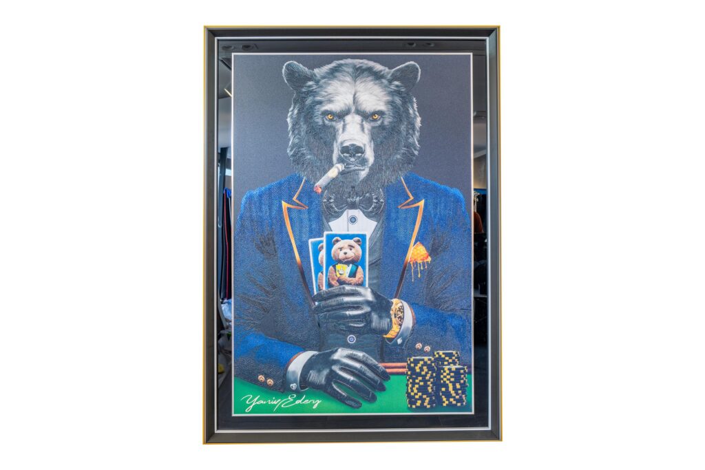 Yaniv Edery - Bear Pok'Art Blue Suit is a work of art that exudes power, mystique and luxury. The proud bear sits firmly at the poker table, dressed in a stylish blue suit with sophisticated orange accents. His intense gaze and stern posture immediately convey a sense of control and determination. This work combines elegance with the raw energy of a predator. The bear smokes a cigar and holds his cards close. He exudes confidence and composure, exactly the way a winner behaves. The chips and gold details enhance the atmosphere of luxury and power. It is a game of risk and reward, as well as attitude and charisma. The blue suit plays a central role in this. Blue symbolizes reliability, strength and wisdom. Combining this with the fearless bear creates a unique harmony between style and force of nature. Every detail, from the texture of the fur to the sharp lines of the suit, has been carefully crafted. This artwork tells more than just a story about poker. It is about strategy, strength and the art of controlling emotions. In life, as in poker, balance between guts and thoughtfulness is essential. The bear embodies just that: a master of strength and composure. Bear Pok'Art Blue Suit is not just a piece of art. It is a statement. A powerful addition to any space. A work of art that continues to captivate, challenge and inspire.