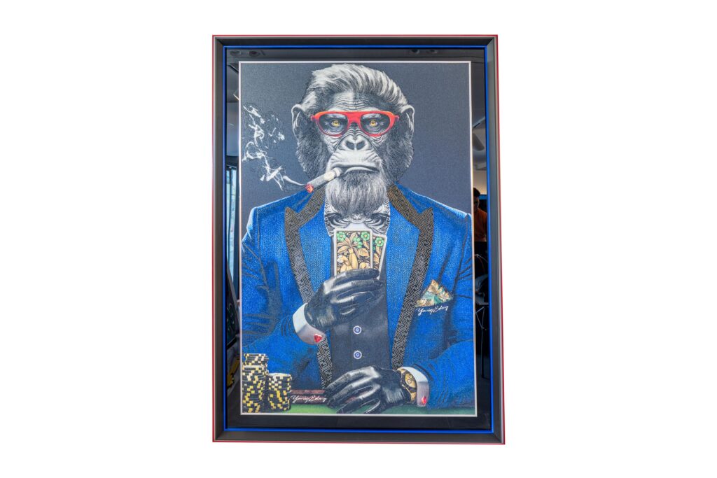Monkey Poker Blue Suit - Yaniv Edery Monkey Poker Blue Suit by Yaniv Edery, exudes power and irony. A monkey in a stylish blue suit, red glasses and cigar. The image immediately emphasizes power, status and play. Every line is carefully placed. Every detail exudes humor, but also a sharp critique of luxury and superficiality. The cards in his hand symbolize strategy, chance and bluffing. Moreover, the poker coins and watch reinforce the theme of wealth. The result is an impressive work of art that combines elegance with satire. The colors are powerfully chosen. The blue suit exudes prestige. The red glasses immediately attract attention. In addition, the smoke from the cigar creates a playful dynamic. The contrast between animal instinct and human arrogance is palpable. This creates tension as well as curiosity. With Monkey Poker Blue Suit, Edery provides a visual game that confronts. It is not only a work of art, but also a mirror. Those who look see luxury and power, but also a subtle warning. For behind every facade lurks a reality of choices, risks and illusions. This makes the work universal and timeless.