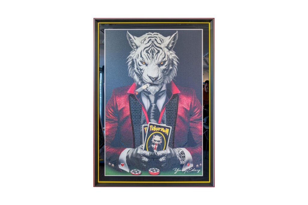 Yaniv Edery - Tiger Pok'Art Red is a work that brings together power, boldness, emotion and luxury. The white tiger in a bright red suit exudes power, luxury and charisma. His intense gaze, the cigar in his mouth and the poker cards in his hands symbolize strategy, risk and play. This artwork shows how elegance meets raw power. The red of the suit is striking and not chosen by chance. Red represents passion, energy and determination. As a result, the artwork immediately attracts attention. Moreover, it gives the tiger an almost regal appearance. Every detail has been carefully applied: from the texture of the suit to the realistic rendering of the tiger's head. This makes the work both decorative and meaningful. Place this work of art in a room and the atmosphere instantly changes. The work dominates and inspires at the same time. It invites conversation and prompts reflection. It combines animal power with the symbolism of poker: choices, strategy and daring. This makes it not only a visual eye-catcher, but also a statement about guts and power.