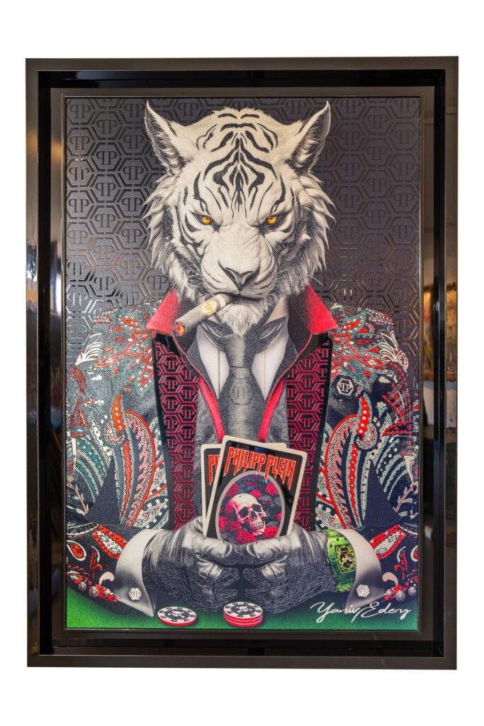 Yaniv Edery - Tiger Poker Philipp Plein Black and Red is a work of art that brings together luxury and power. The white tiger, symbol of dominance and strategy, takes center stage. He smokes a cigar, holds cards tightly and exudes absolute self-assurance. The intensity of his gaze makes an immediate impression. The combination of black and red in the Philipp Plein suit enhances the tension. The pattern is rich, detailed and extravagant. This gives the tiger not only authority but also style and modernity. It is a work that exudes energy and luxury. The poker element adds another layer. Poker is a game of strategy, daring and patience. Edery manages to translate exactly that into this image. The chips, cards and details emphasize that there is more at play here than a game. It is a struggle for power and control. Every detail is carefully placed. As a result, the work feels vibrant and powerful. The contrasting colors create tension, while the composition maintains balance and harmony. As such, this artwork is more than decoration. It is a statement, an eye-catcher that completely transforms a space. Whoever sees this work feels the intensity. It invites you to stand still, observe and experience the power of the tiger. This is art that continues to fascinate.