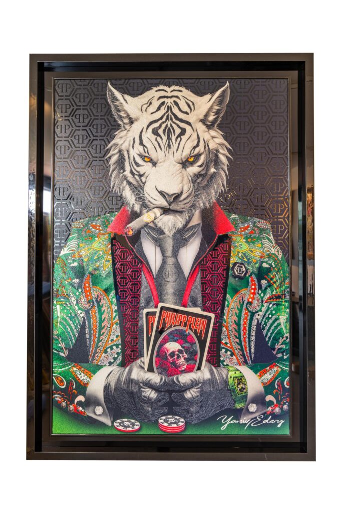 Yaniv Edery - Tiger Poker Philipp Plein Black and Green is a work of art that perfectly blends power, luxury and style. The white tiger, with his intense gaze and cigar, sits stately behind a poker table. He firmly holds the winning cards. The detailed elaboration of the Philipp Plein jacket in black and green makes the work extra striking. This is not just another painting. It is a symbol of power, guts and sophistication. The tiger in this work exudes strategy and dominance. His presence commands respect. The combination of poker cards, chips and the luxurious design of the coat enhances the story. It is art that goes beyond decoration. It tells something about victory, choices and confidence. The black and green patterns add depth and energy. This gives the tiger an even stronger look. Every detail, from the patterns on the coat to the smoke from the cigar, shows how precisely and creatively Yaniv Edery works. This makes the artwork a real eye-catcher. Place this work in a modern room and the atmosphere instantly changes. It brings together tension, power and luxury in one image. This is art that impresses, invites and continues to fascinate.
