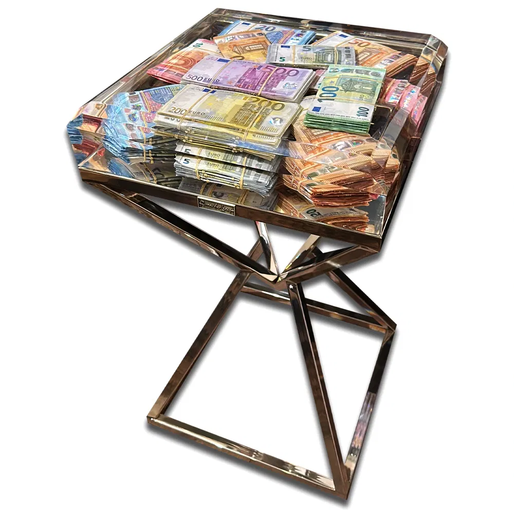 Money Diamond Table van Roy van der Laars is een exclusief kunst- en designobject dat luxe, macht en vakmanschap samenbrengt. Het tafelblad, uitgevoerd in hoogwaardig transparant epoxy, bevat zorgvuldig gerangschikte stapels eurobiljetten in diverse coupures, waardoor een visueel statement van overvloed ontstaat. De glanzende afwerking geeft het geheel een bijna juweelachtige uitstraling, passend bij de naam Diamond. Het onderstel is vervaardigd uit gepolijst metaal in een geometrisch, diamantvormig ontwerp, wat zorgt voor zowel stabiliteit als een moderne, sculpturale look. Deze combinatie van luxe materialen en strakke lijnen maakt het stuk niet alleen functioneel, maar ook een conversation piece van formaat. Met de Money Diamond Table speelt Van der Laars in op thema’s als welvaart, status en de waarde van kunst in onze samenleving. Elk exemplaar is met de hand vervaardigd, waardoor geen twee tafels exact gelijk zijn. Dit maakt het een uniek verzamelobject voor liefhebbers van high-end art en design. De Money Diamond Table is ideaal voor wie zijn interieur wil verrijken met een opvallend en luxueus meesterwerk dat zowel designobject als kunstinstallatie is. Een ultieme uiting van prestige en stijl.